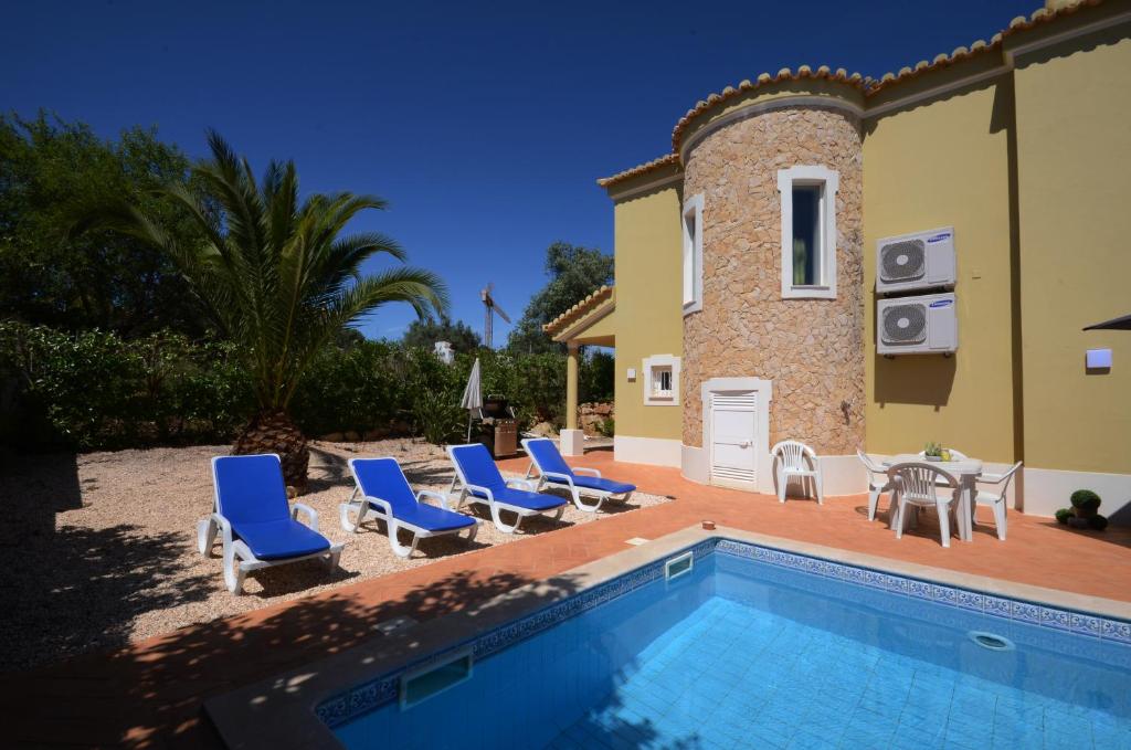 a villa with a swimming pool in front of a house at Casa Da Torre Espetacular V4 Com Piscina in Portimão