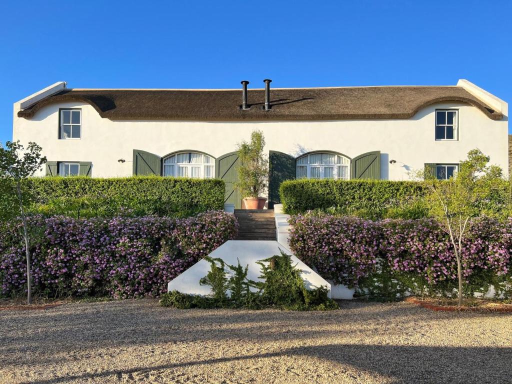 a house with purple bushes in front of it at Penhill Farm West Grange in Nuy