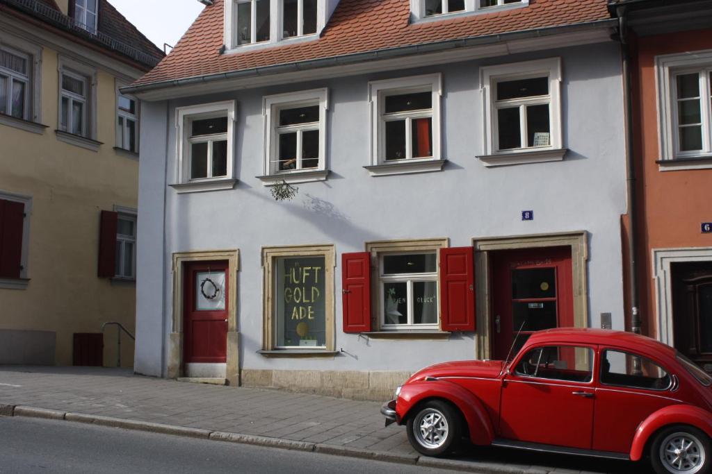 um carro vermelho estacionado em frente a um edifício em Schönerferienwohnen in Bamberg em Bamberg