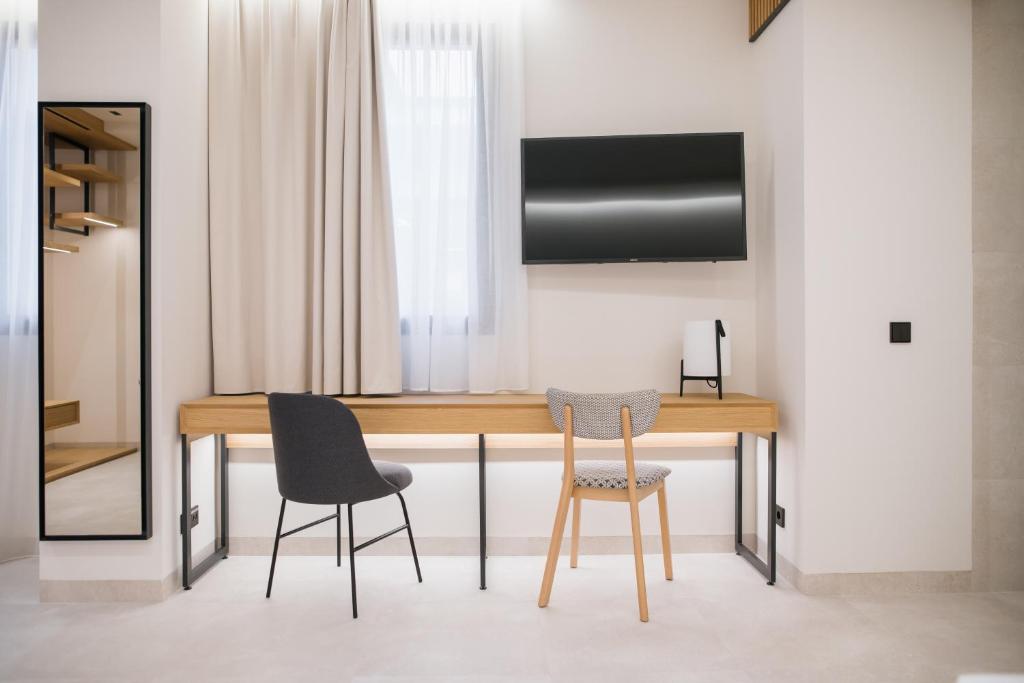 a dining room table with two chairs and a television at MYR Puerta Serranos in Valencia