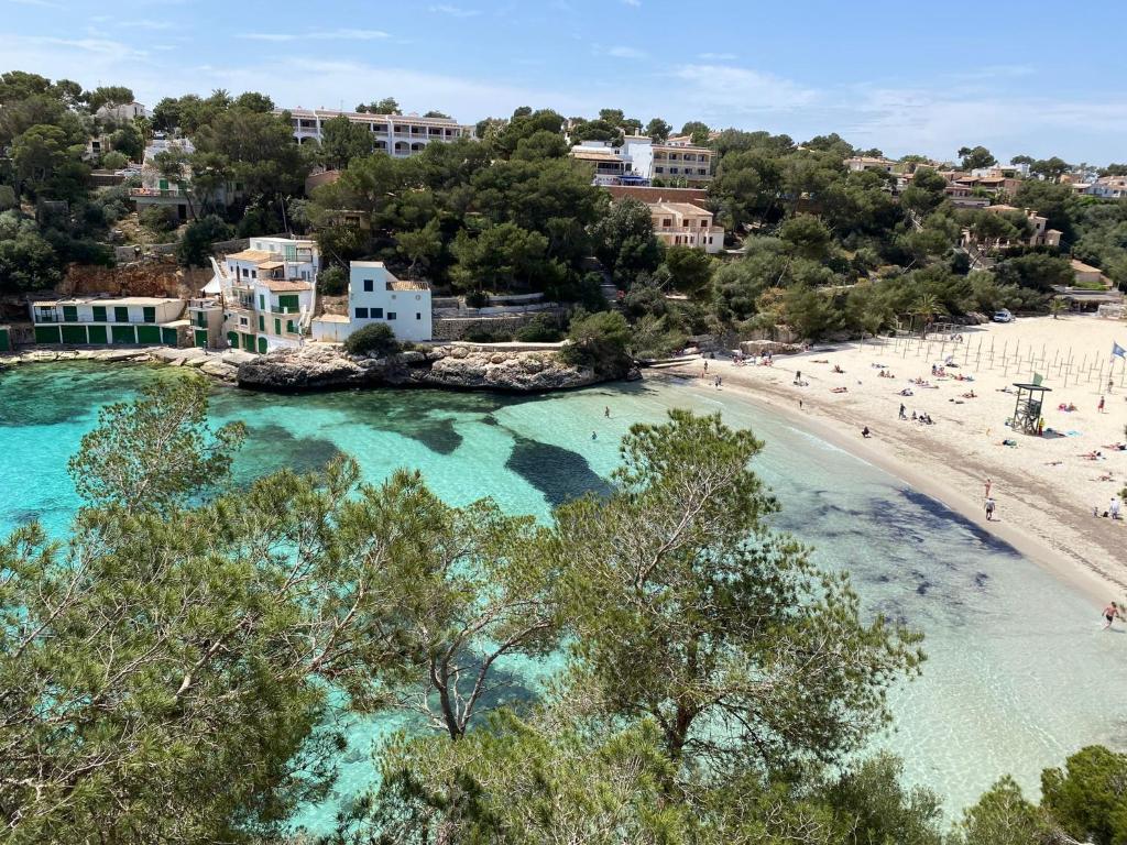 an aerial view of a beach with people in the water at Hostal Palmaria in Cala Santanyi
