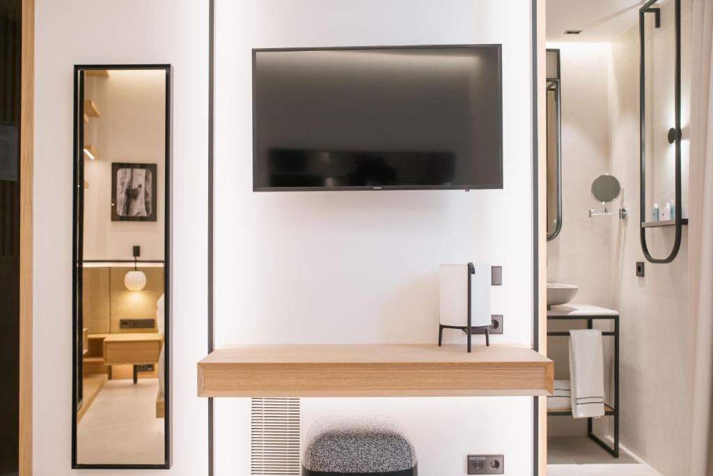 a bathroom with a mirror and a tv on a wall at MYR Puerta Serranos in Valencia
