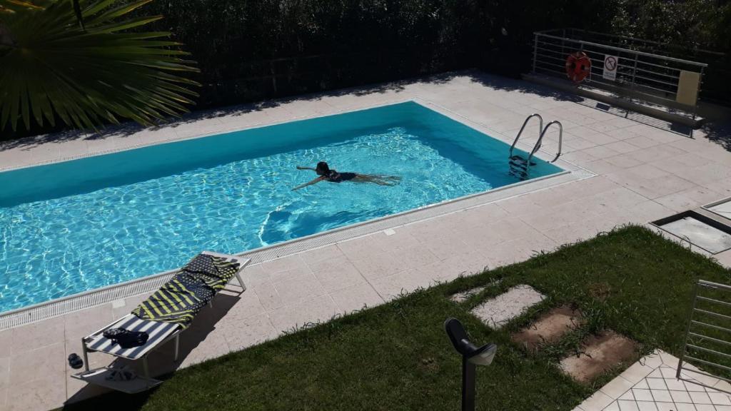 una persona nadando en una piscina en Luxury Apartment with swimming pool, en Lonato