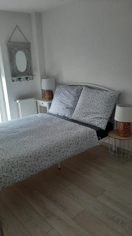 ein Schlafzimmer mit einem Bett, zwei Lampen und einem Spiegel in der Unterkunft Apartament Port in Ostróda
