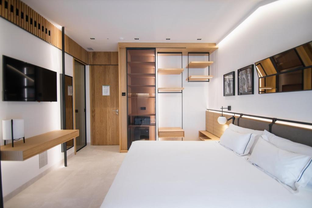 a bedroom with a white bed and a desk at MYR Puerta Serranos in Valencia