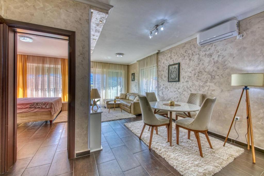 a living room with a table and chairs and a bedroom at ENA Apartment in Kotor