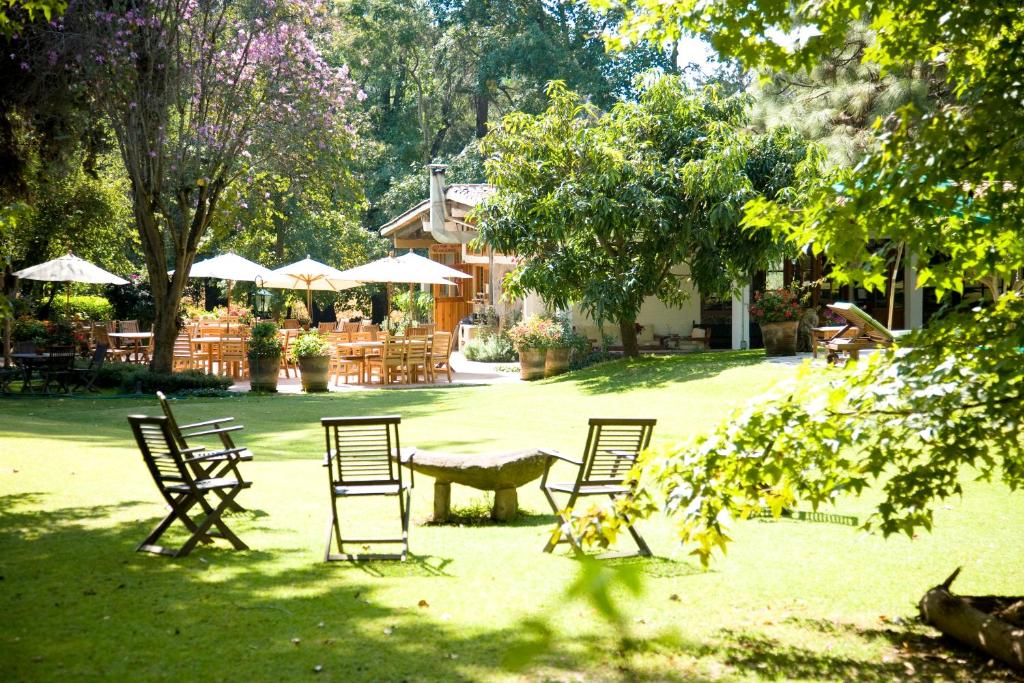 een groep stoelen en een tafel in een tuin bij Hotel Rancho San Cayetano in Zitácuaro