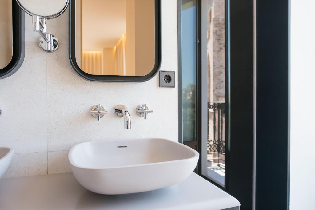 a bathroom with a white sink and a mirror at MYR Puerta Serranos in Valencia