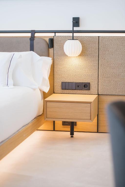 a bedroom with a bed and a table with a night stand at MYR Puerta Serranos in Valencia