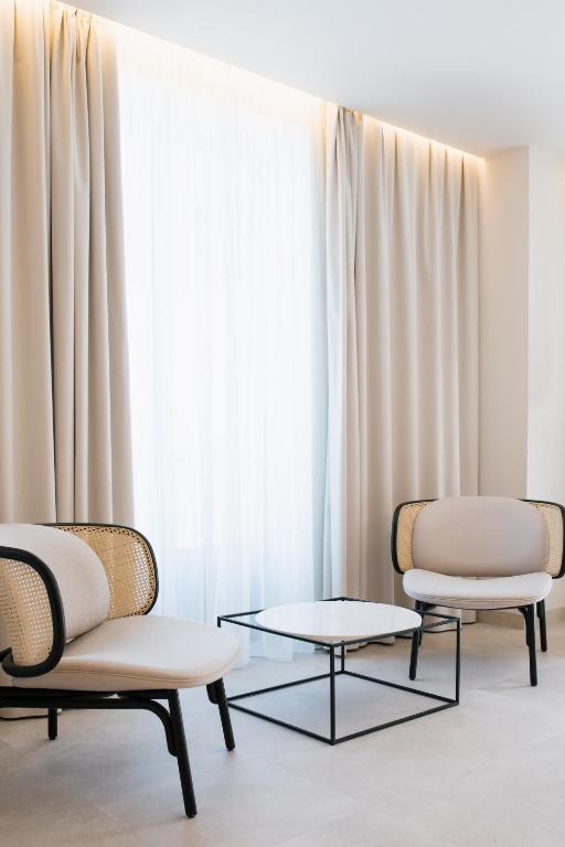 two chairs and a table in front of a window at MYR Puerta Serranos in Valencia