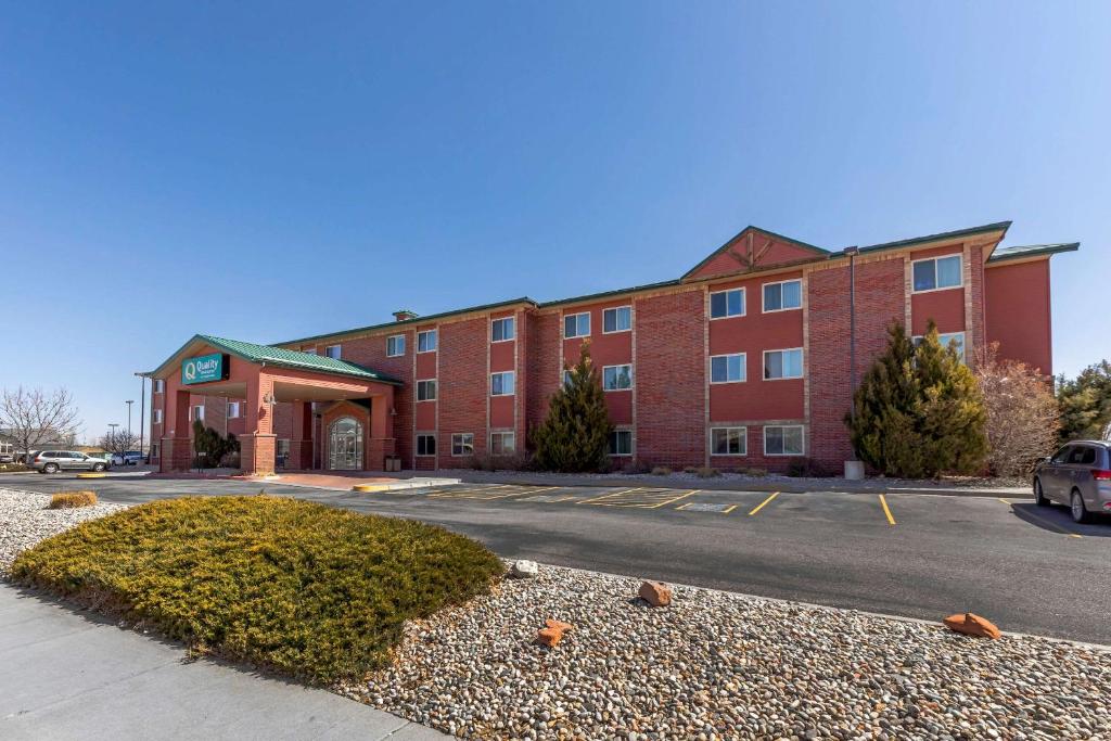 een groot gebouw van rode baksteen met een parkeerplaats bij Quality Inn & Suites Wellington – Fort Collins in Wellington