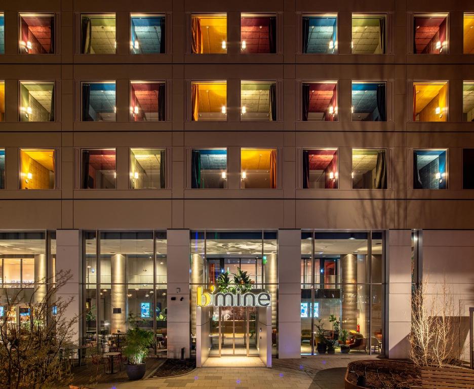 una vista exterior de un edificio con ventanas iluminadas en b'mine Hotel Frankfurt Airport en Frankfurt