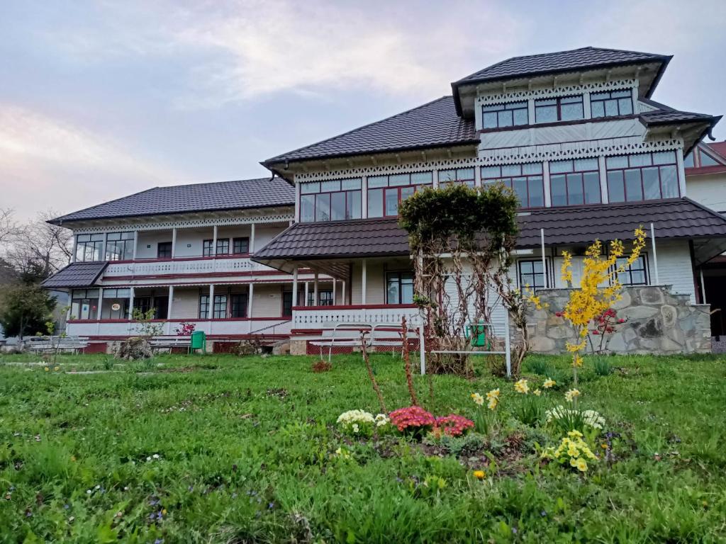 a large house with a garden in front of it at Padurea De Argint in Văratec