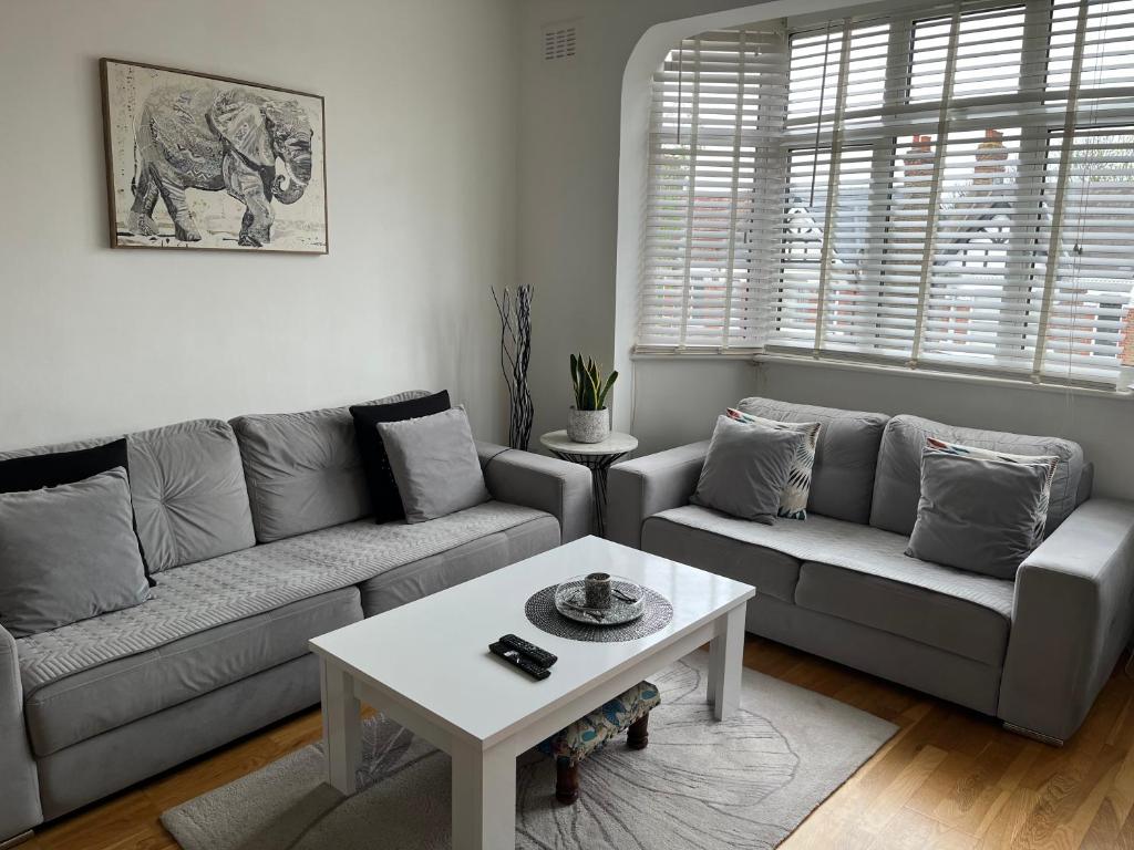 uma sala de estar com um sofá e uma mesa em Lovely 2-bedroom apartment in Zone 2 London em Londres