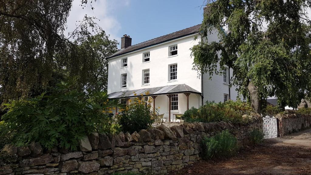 Casa blanca con pared de piedra en Upper Buckton B&B en Leintwardine
