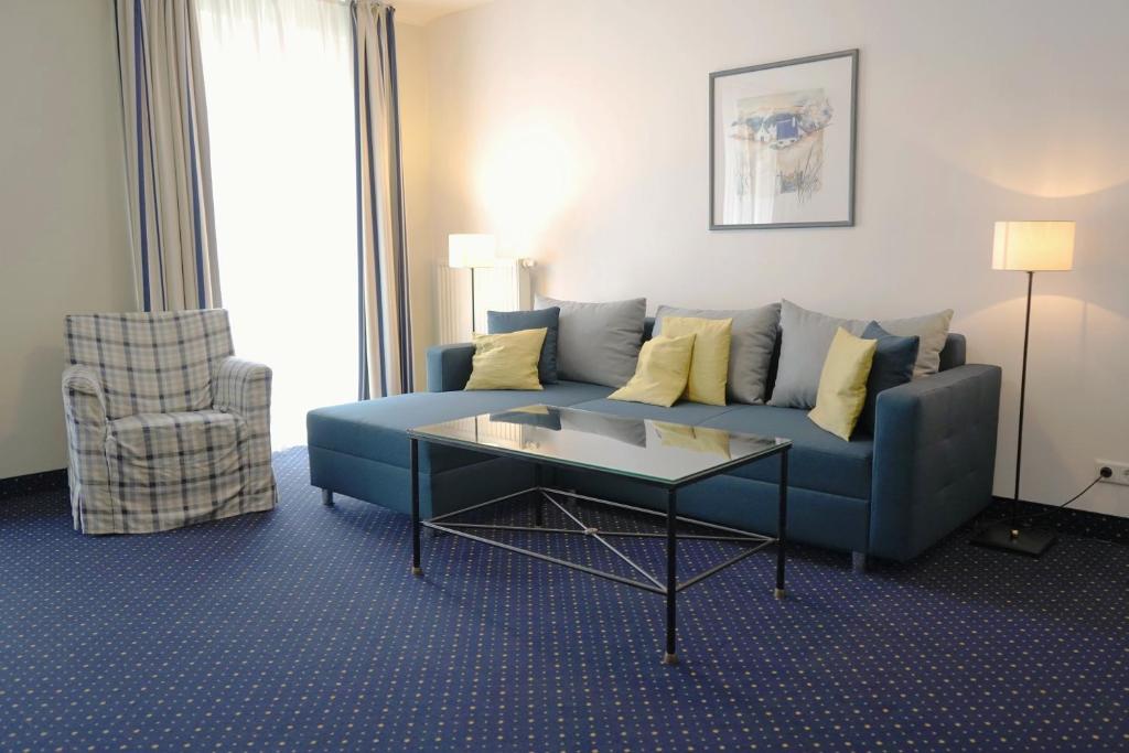 a living room with a blue couch and a table at Haus Seeblick Wohnung 326 in Zingst