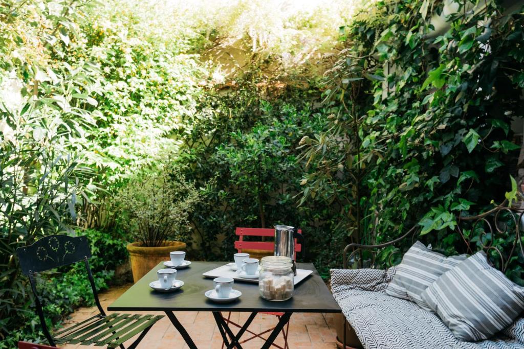 une table avec des tasses et des soucoupes sur une terrasse dans l'établissement Magnifique maison de ville, La Rochelle, à La Rochelle