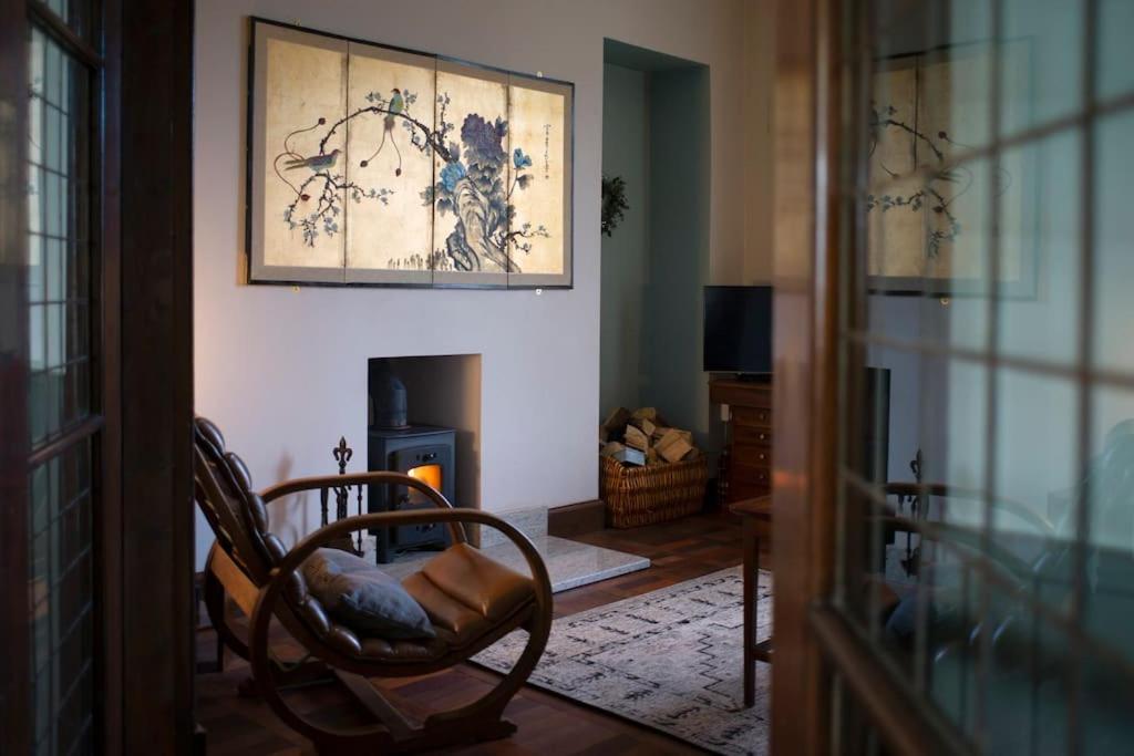 a living room with a chair and a fireplace at The Presbytery, Forres in Forres