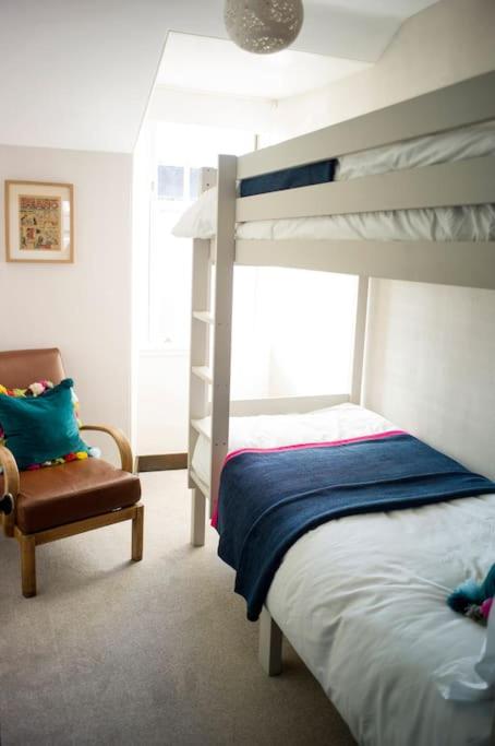 una camera da letto con un letto a castello e una sedia di The Presbytery, Forres a Forres
