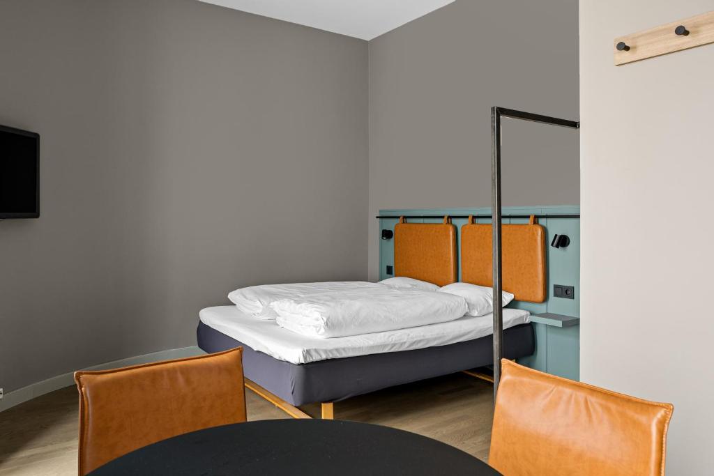 a bedroom with a bed and a table and chairs at Comfort Hotel Børsparken in Oslo