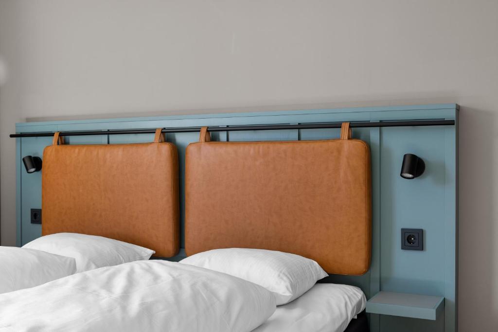 two beds with orange and white pillows at Comfort Hotel Børsparken in Oslo