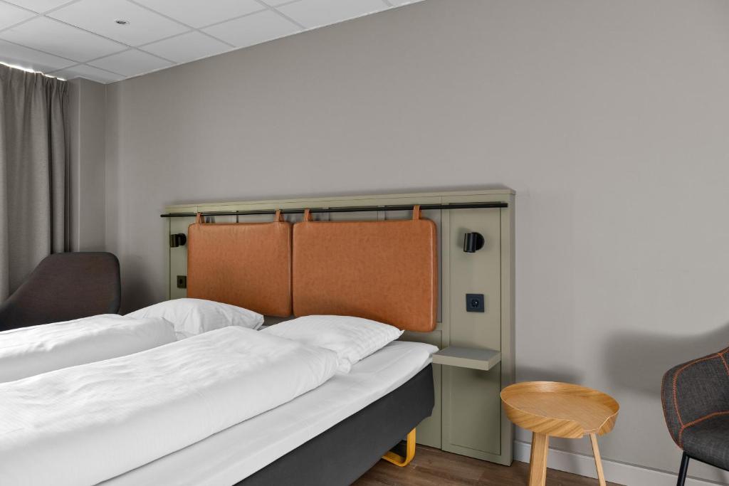 a hospital room with two beds and a chair at Comfort Hotel Børsparken in Oslo