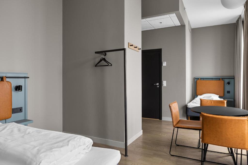 a room with a bed and a table and chairs at Comfort Hotel Børsparken in Oslo