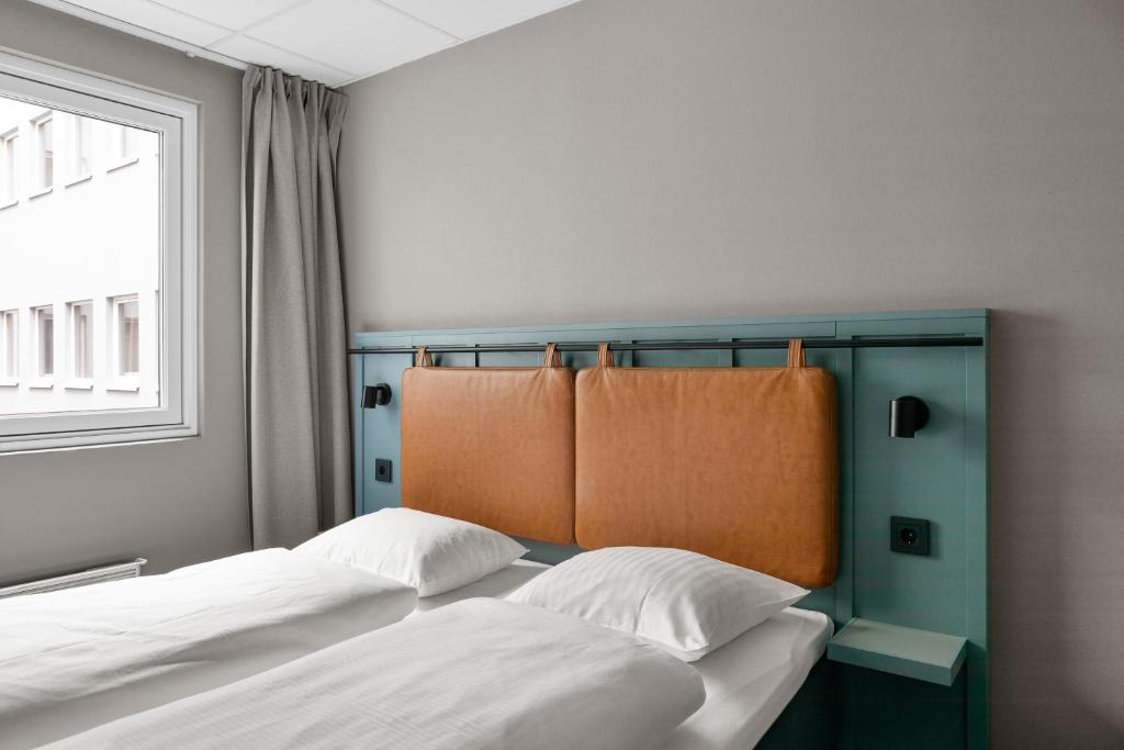 a bedroom with two beds and a window at Comfort Hotel Børsparken in Oslo