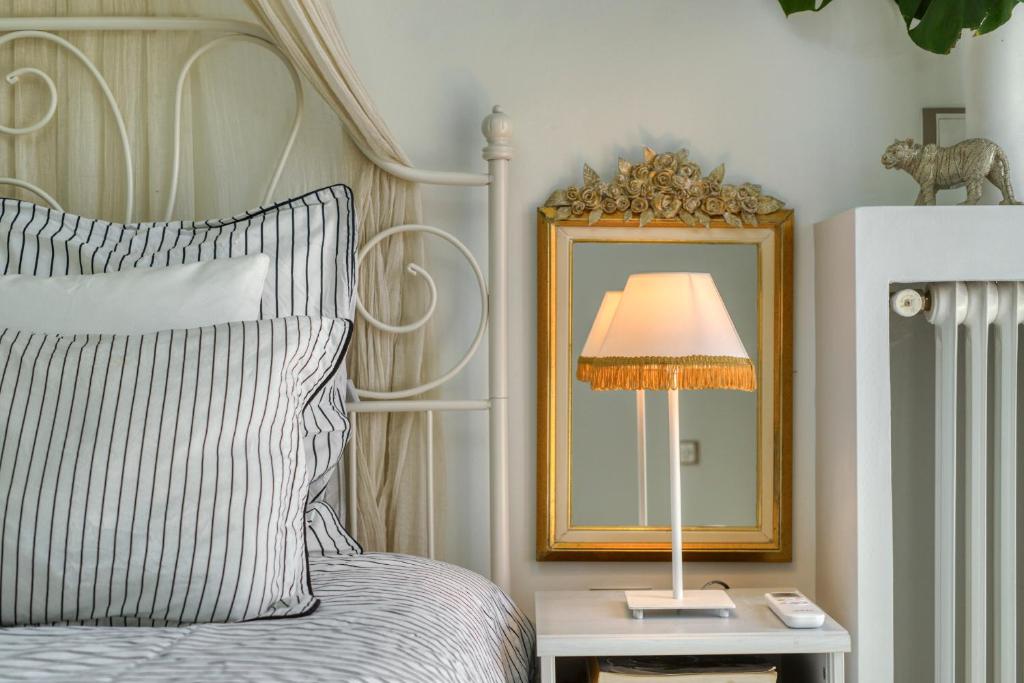 ein Schlafzimmer mit einem Bett mit einer Lampe und einem Spiegel in der Unterkunft Luxury Apartments Zeas Piraeus in Piräus