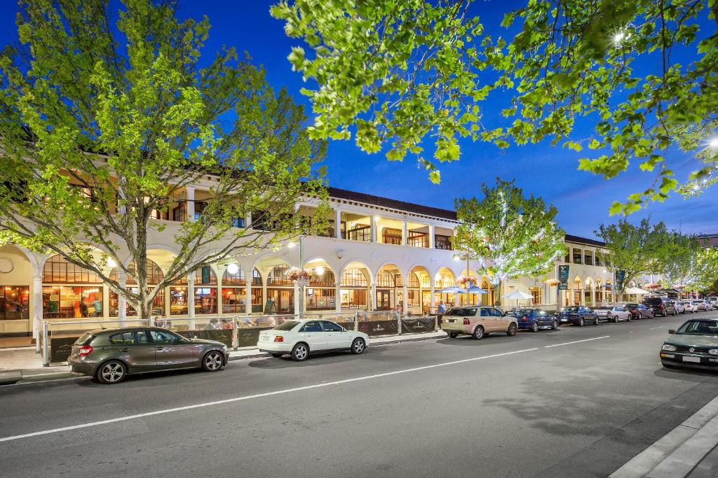 eine Straße mit Autos, die vor einem Gebäude geparkt sind in der Unterkunft Quest Canberra in Canberra