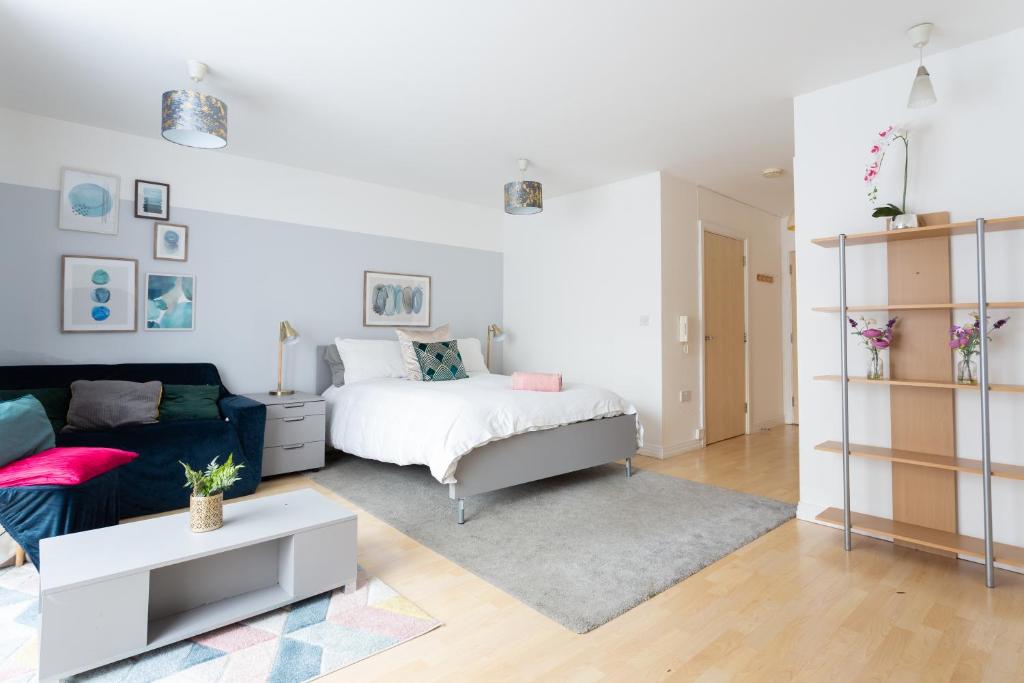 a living room with a bed and a couch at Modern Spacious studio close to station in London