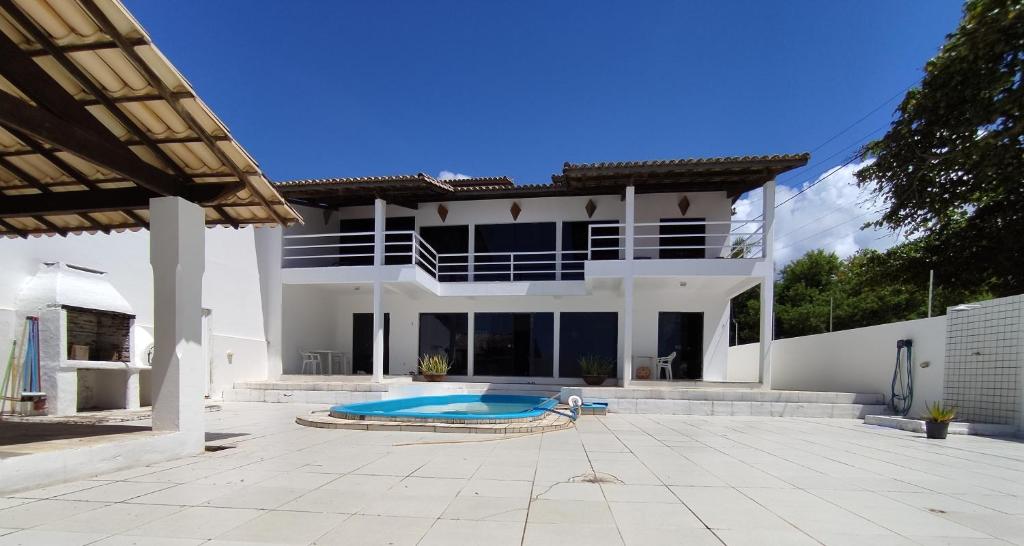 ein großes weißes Haus mit einem Pool in der Unterkunft Casa Joaquim in Vera Cruz de Itaparica