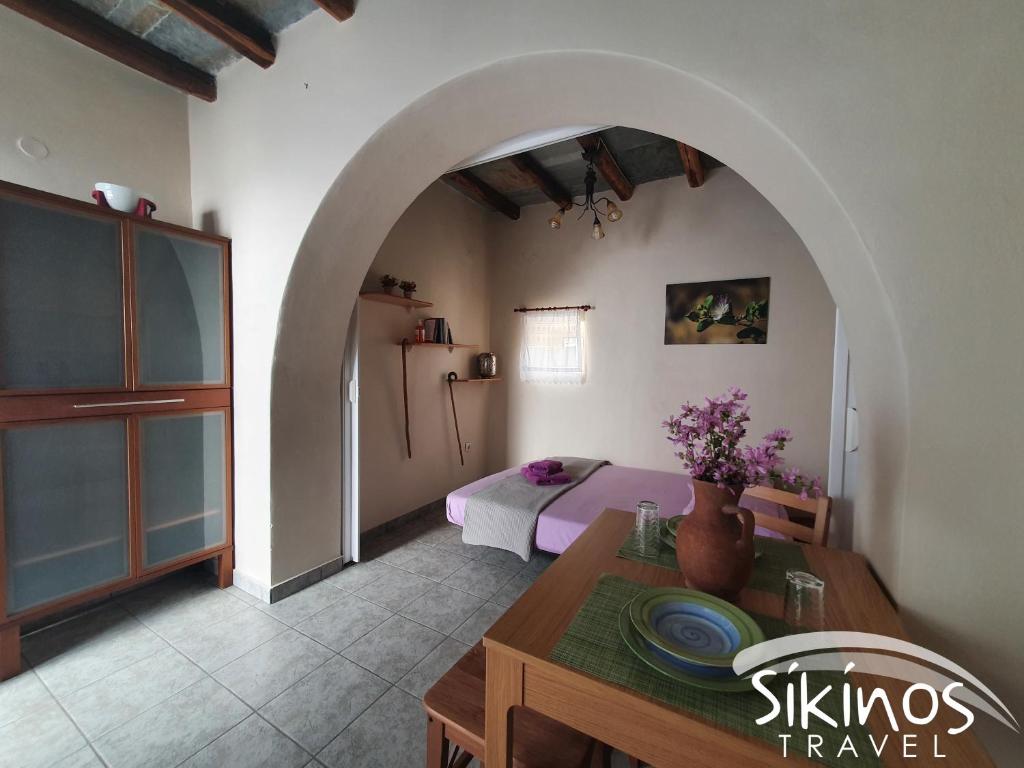 a living room with a table and a bedroom at Sikinos Summer Nest in Síkinos