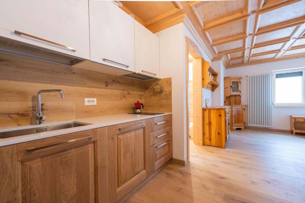 a kitchen with wooden cabinets and a sink at Bilocale Fiore in Campitello di Fassa