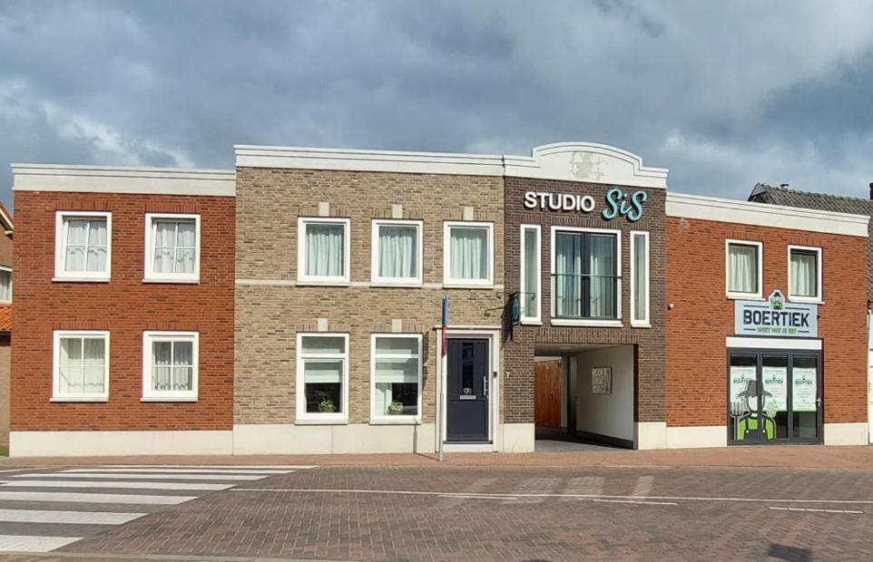 a brick building with a store on a street at Hotel Studio SIS in Steenbergen
