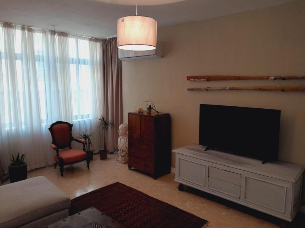 a living room with a flat screen tv and a couch at Lovely two bedroom apartment seconds from the Sea! in Sliema