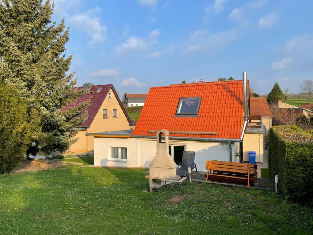 una casa con techo naranja y un banco en el patio en Appartmenthaus, en Wethau