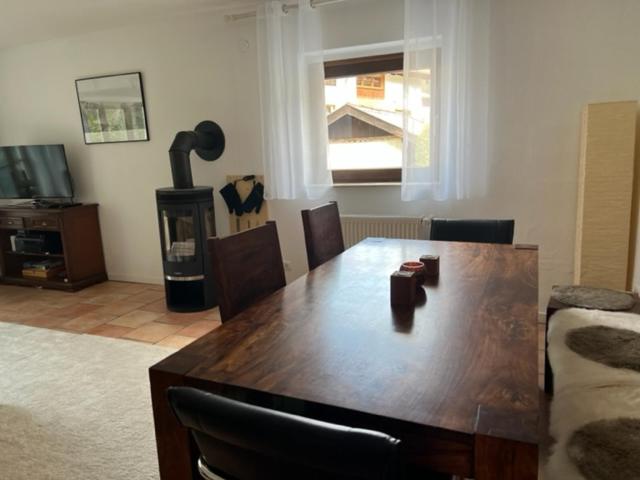 a living room with a wooden table and a couch at Apartment BERGfamilie - gemütlich ausgestattet, ruhig und familienfreundlich in Schliersee