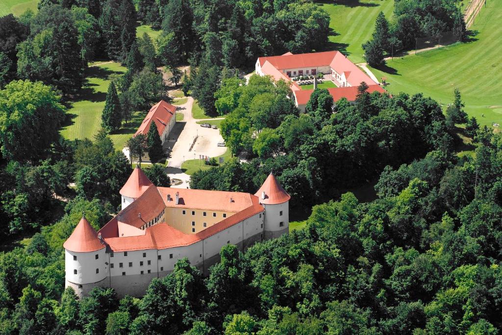 un castillo en la cima de una colina con árboles en Mokrice Castle Estate en Brežice