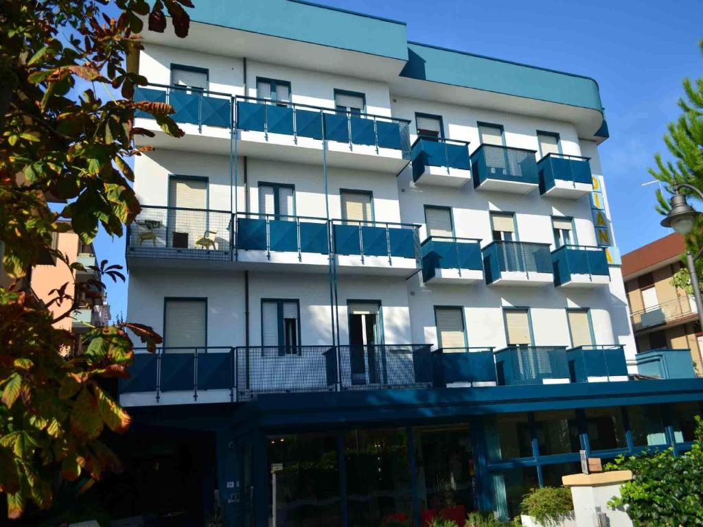 biały budynek z niebieskimi balkonami w obiekcie Hotel Diana w mieście Bellaria-Igea Marina