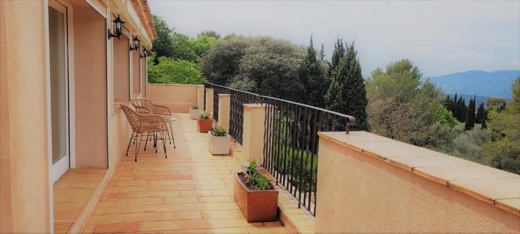 a balcony with chairs and plants on a building at Domaine du Paradis des Oiseaux in Mougins