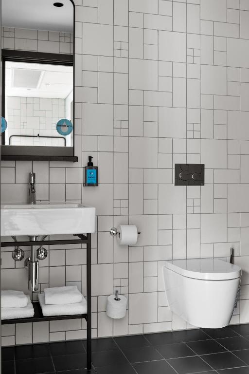 a bathroom with a sink and a tub and a mirror at Comfort Hotel Xpress Youngstorget in Oslo