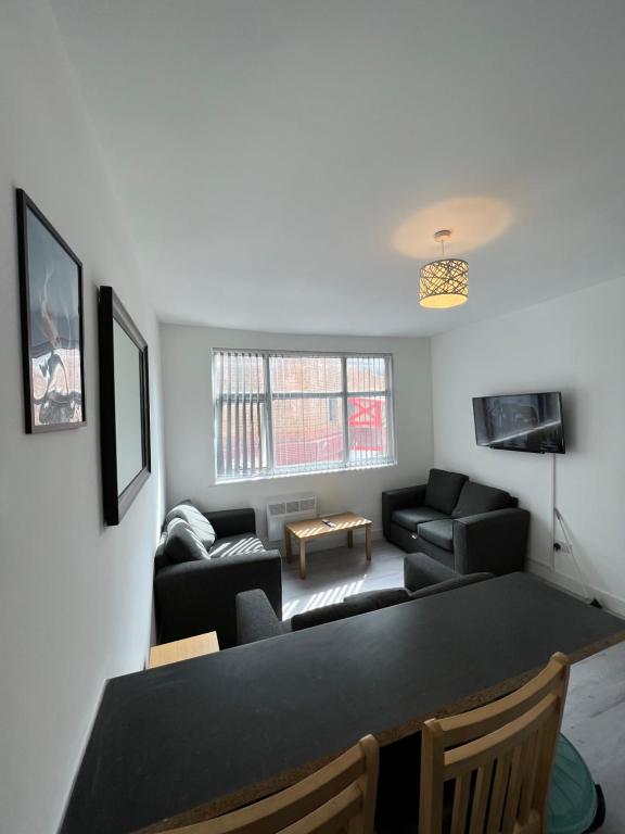 a living room with a black table and a couch at The Bake Apartment - 5 bedroom Large Apartment sleeps up to 16 person in Newcastle upon Tyne