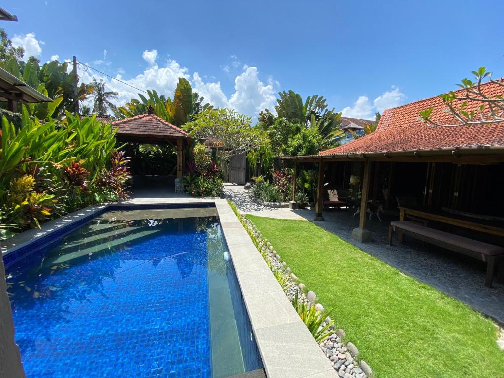 a swimming pool in the yard of a house at Balian Beach Villa in Selemadeg