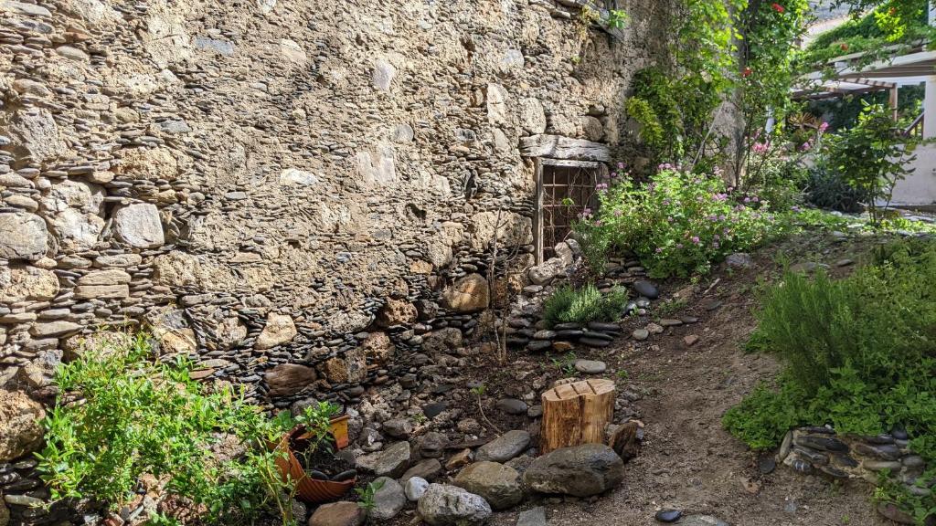 a stone building with a garden in front of it at Pension Irene in Sougia