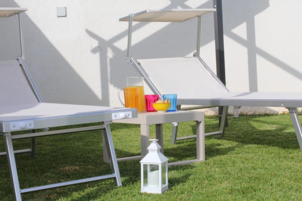 a picnic table and two chairs on the grass at Appartamento Roberti in Corsano