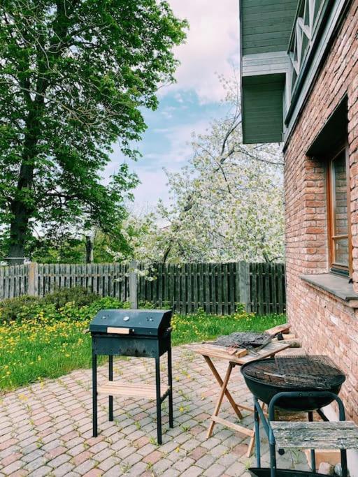 a grill sitting on a brick patio next to a building at Spacious family house in the city centre in Pāvilosta