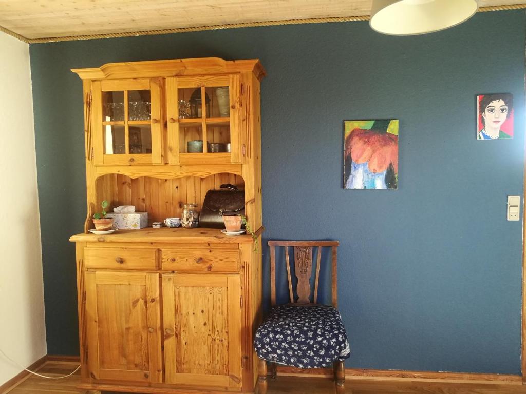 Cette chambre comprend une armoire en bois et une chaise. dans l'établissement Green vagon, farm b&b rooms for rent, à Hjørring