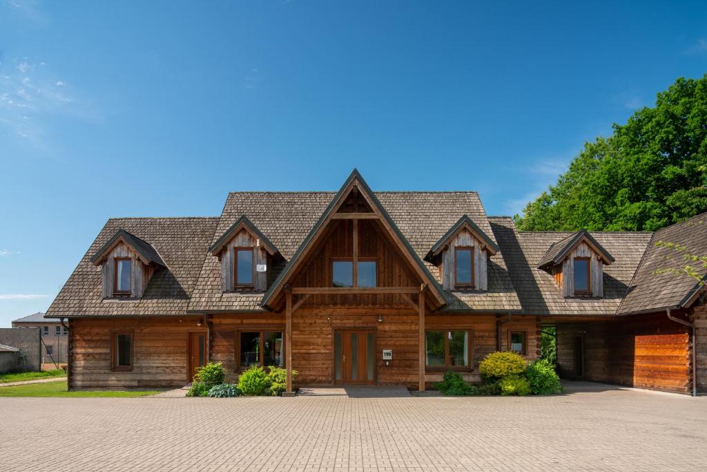 una grande casa in legno con tetto a gambero di Cedrový penzion a Dobříkov