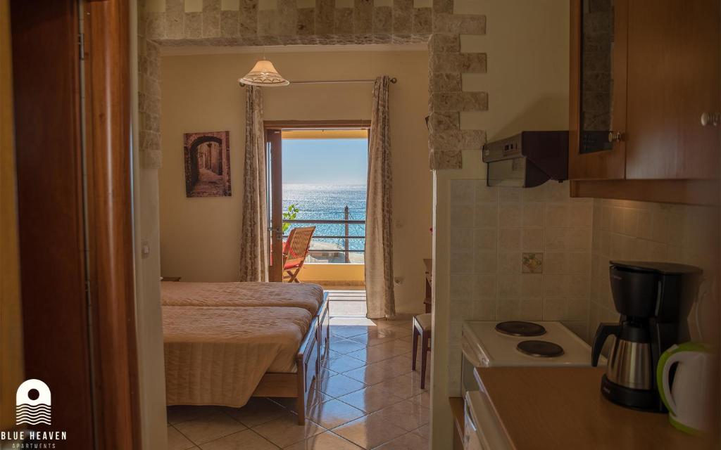 a room with a kitchen with a view of the ocean at Blue Heaven Apartments in Agios Georgios Pagon